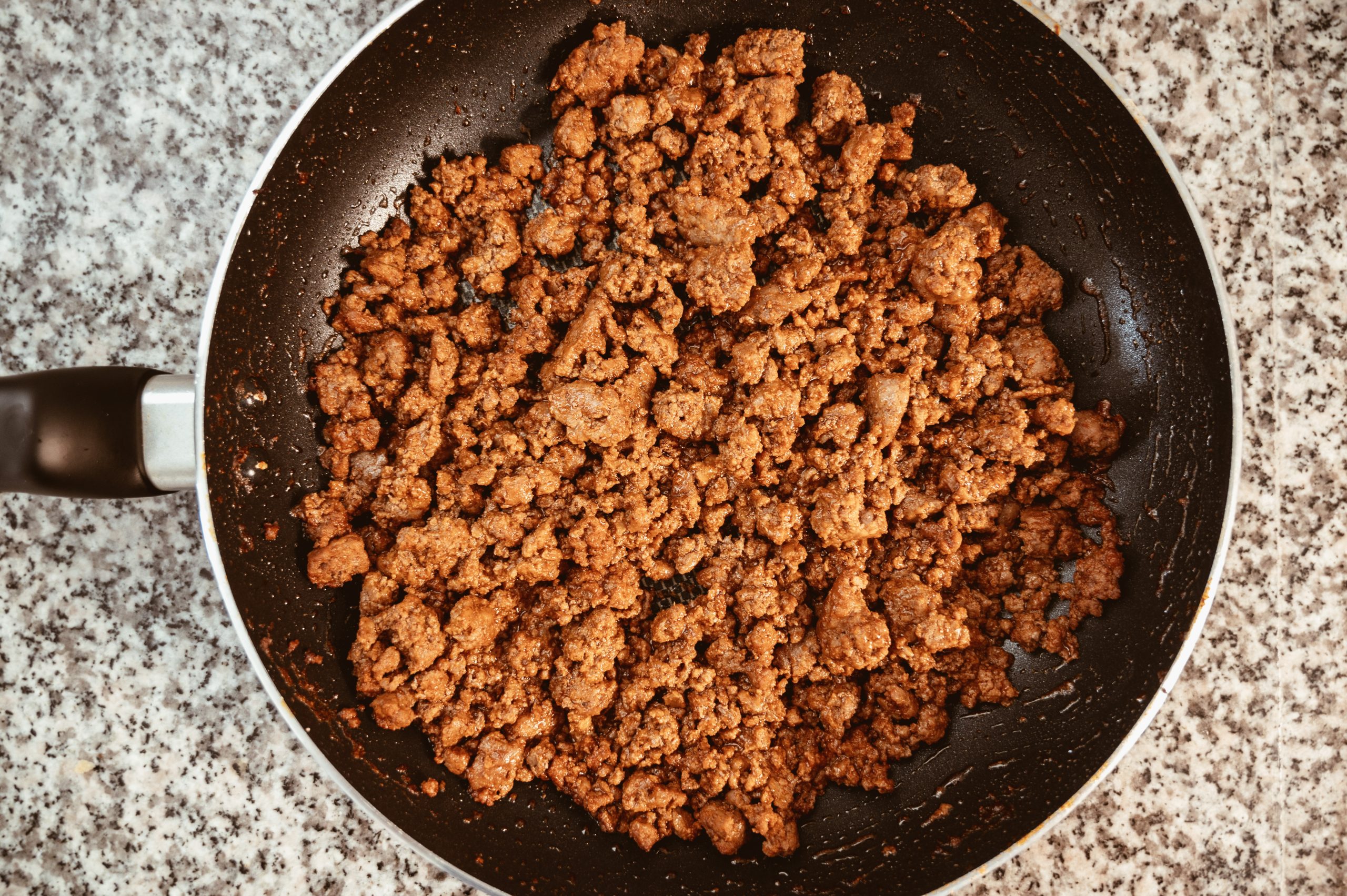 ground beef cooking in a skillet, browned and crumbled for taco filling