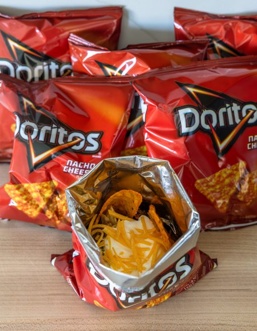 walking taco served in an open Doritos bag filled with seasoned ground beef, lettuce, cheese, and sour cream